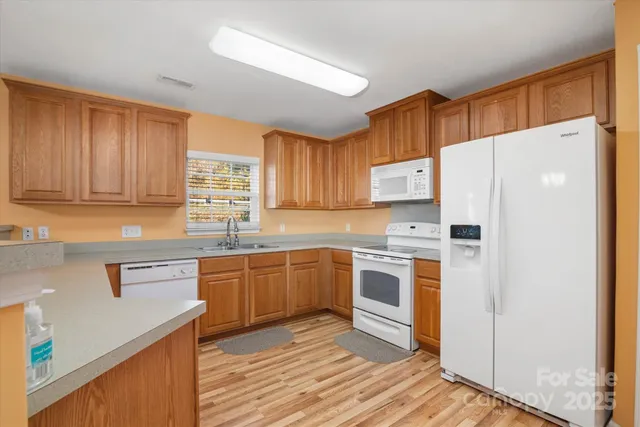 a kitchen with stainless steel appliances granite countertop a refrigerator sink and stove