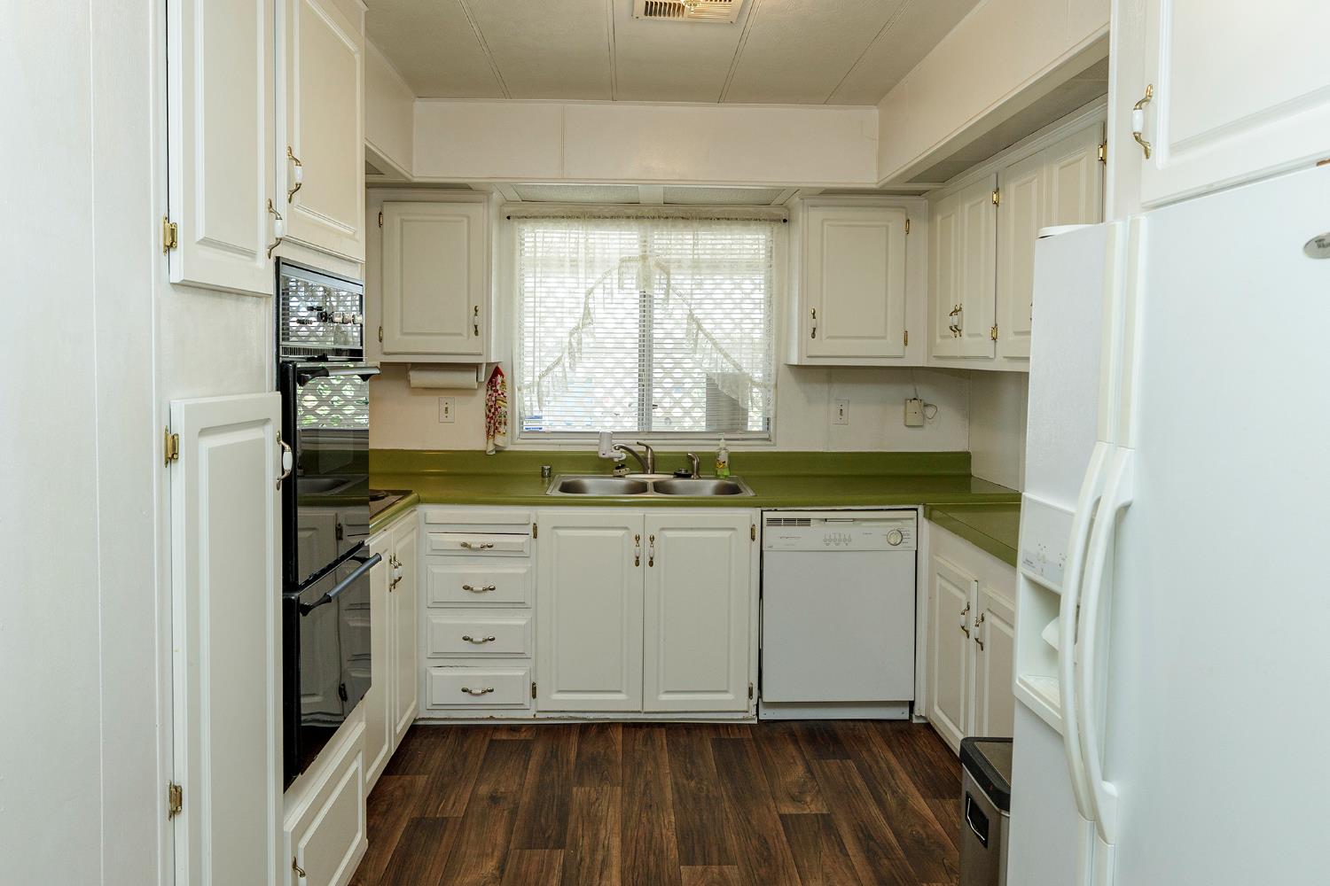 4837 Faith Home Road, Unit 4 Ceres, CA 95307 - Photo 18 of 42 a kitchen with stainless steel appliances granite countertop a stove a refrigerator and white cabinets with wooden floor