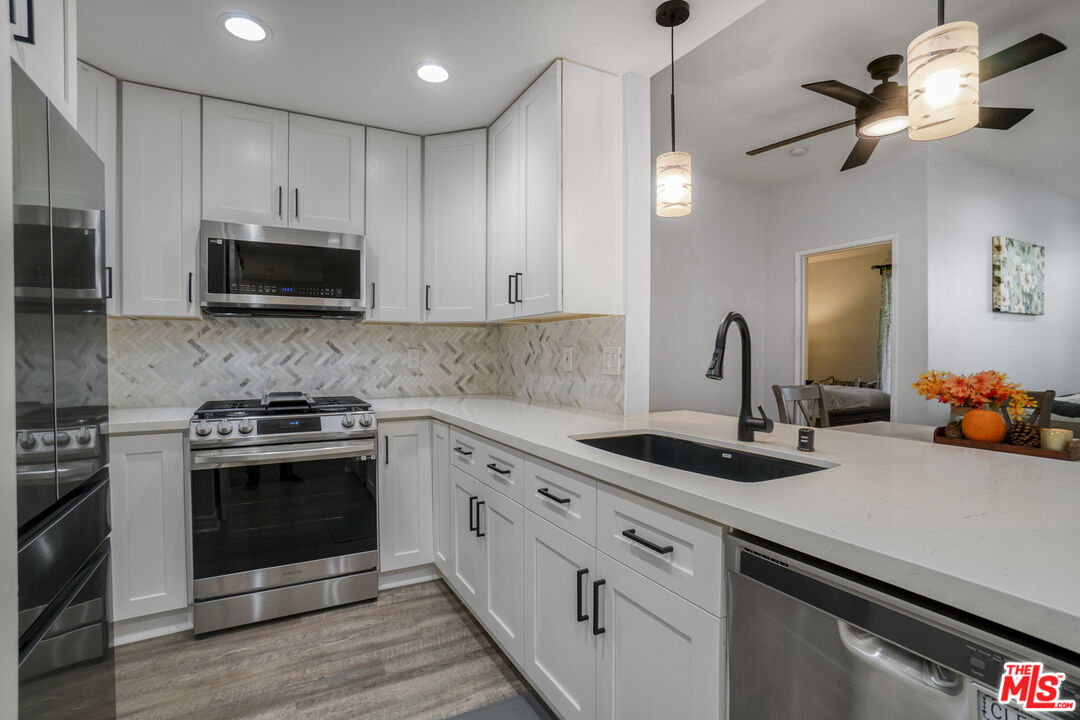 10401 Garden Grove Boulevard, Unit 44 Garden Grove, CA 92843 - Photo 11 of 26 a kitchen with stainless steel appliances granite countertop a sink and a stove top oven