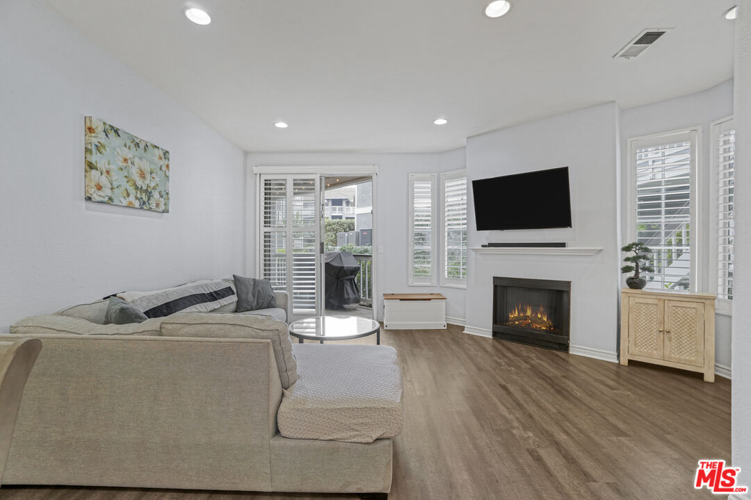 10401 Garden Grove Boulevard, Unit 44 Garden Grove, CA 92843 - Photo 3 of 26 a living room with furniture a fireplace and a flat screen tv