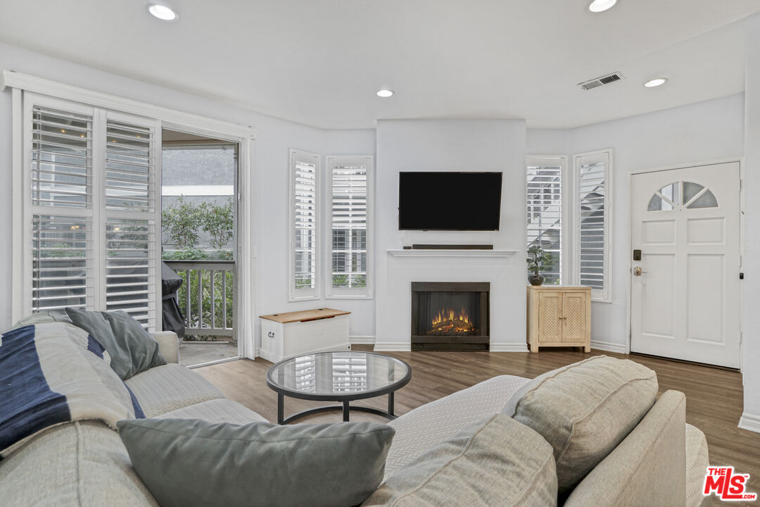 10401 Garden Grove Boulevard, Unit 44 Garden Grove, CA 92843 - Photo 4 of 26 a living room with furniture a fireplace and a flat screen tv