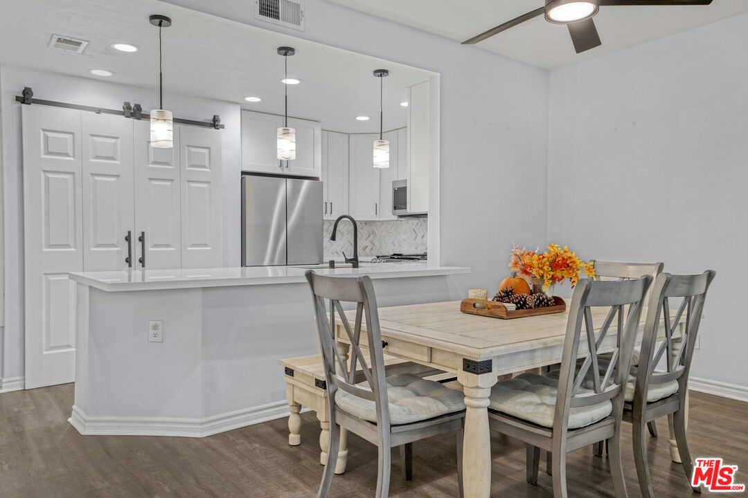 10401 Garden Grove Boulevard, Unit 44 Garden Grove, CA 92843 - Photo 7 of 26 a kitchen with stainless steel appliances kitchen island granite countertop a dining table chairs and a refrigerator
