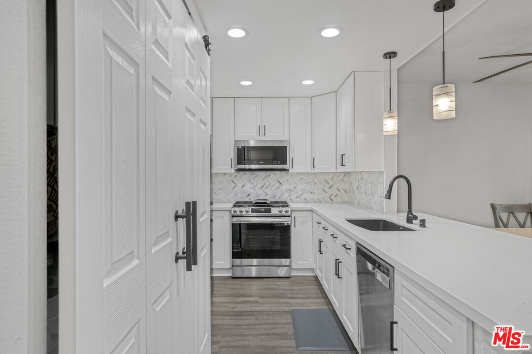 10401 Garden Grove Boulevard, Unit 44 Garden Grove, CA 92843 - Photo 9 of 26 a kitchen with stainless steel appliances granite countertop a sink and a stove