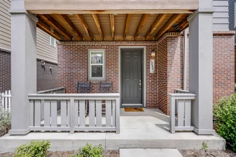 a view of wooden house with large windows and plants