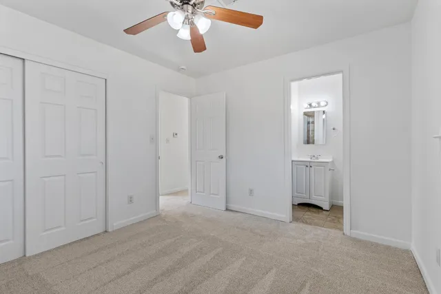a view of a backyard house with large trees and wooden fence