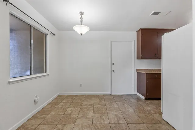 a view of an empty room with a fireplace and a window