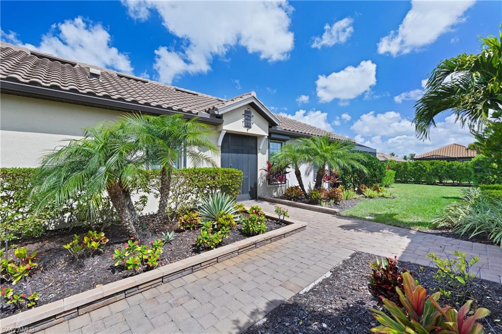 15214 Tolmino Street Naples, FL 34114 - Photo 30 of 47 a front view of a house with a garden