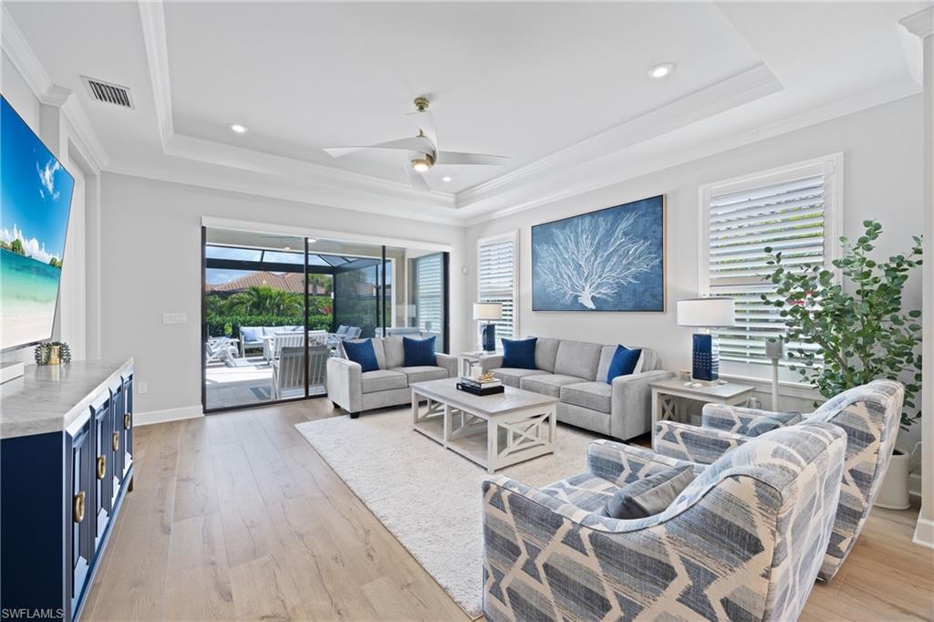 15214 Tolmino Street Naples, FL 34114 - Photo 3 of 47 a living room with furniture large window and wooden floor