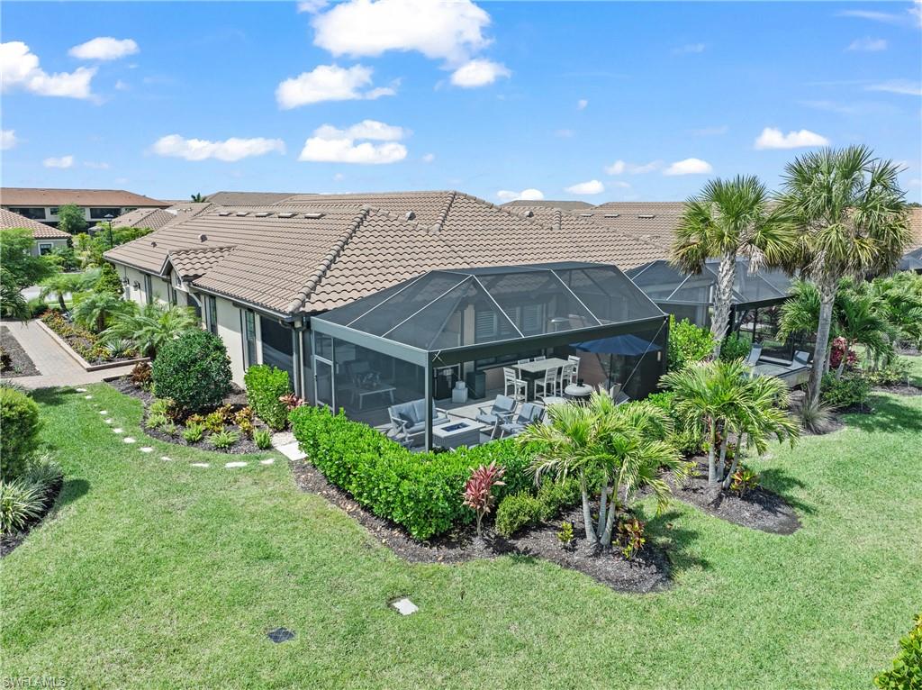 15214 Tolmino Street Naples, FL 34114 - Photo 35 of 47 a view of a garden with a bench under an umbrella