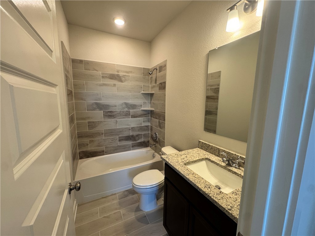 2409 Rooke Road Bryan, TX 77807 - Photo 3 of 11 a bathroom with a granite countertop sink toilet and shower