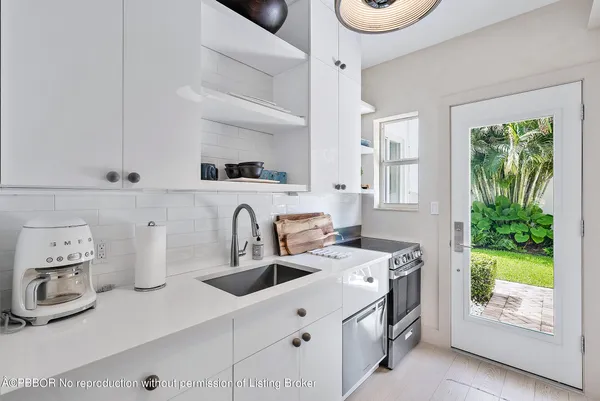 a kitchen with kitchen island a stove a sink and a microwave