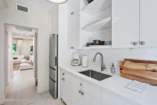 a kitchen with stainless steel appliances a sink a stove and white cabinets