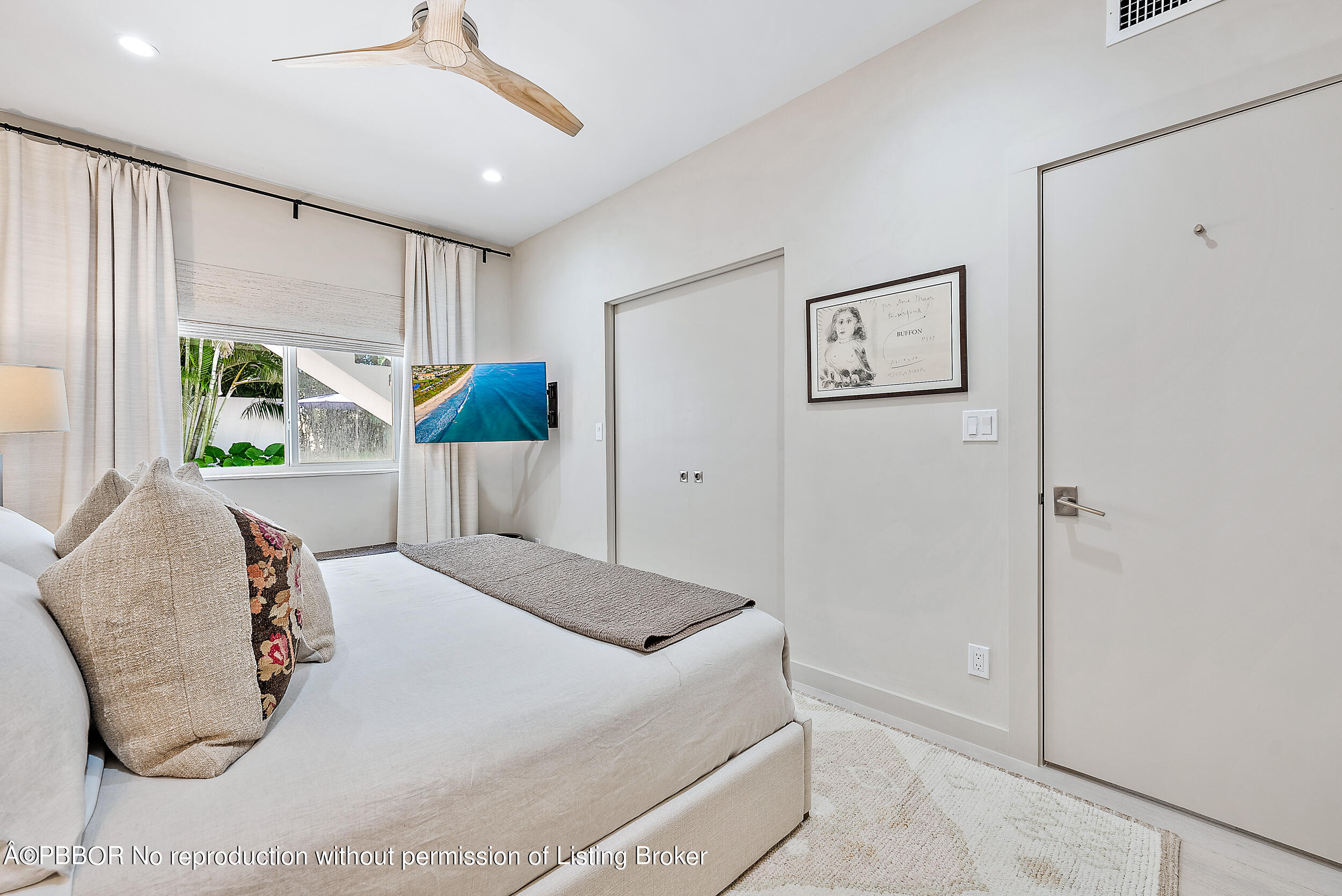 220 Atlantic Avenue, Unit 3 Palm Beach, FL 33480 - Photo 16 of 36 a bedroom with a bed and glass windows