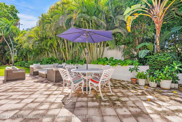 a view of a patio with a table and chairs under an umbrella