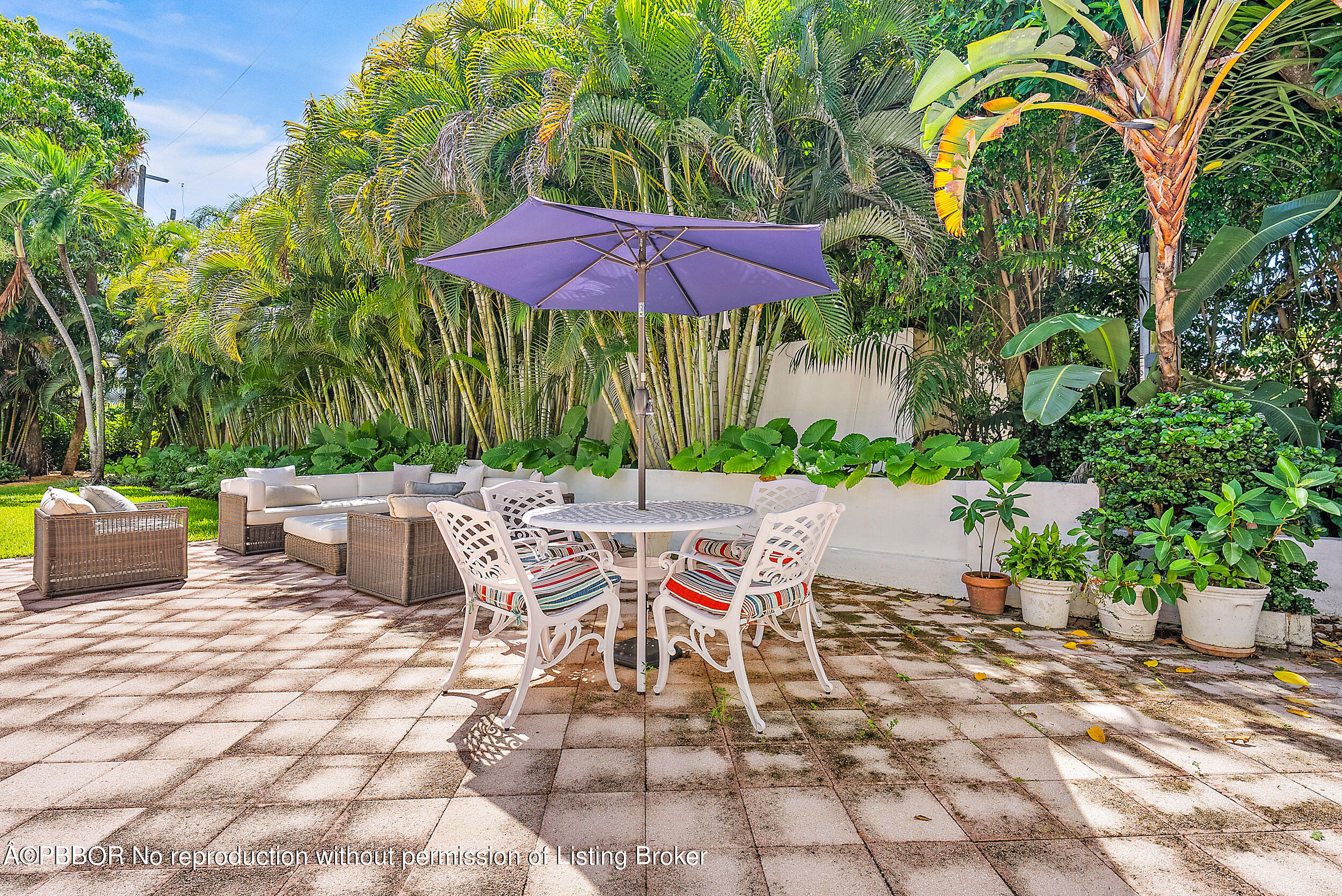 220 Atlantic Avenue, Unit 3 Palm Beach, FL 33480 - Photo 23 of 36 a view of a patio with a table and chairs under an umbrella