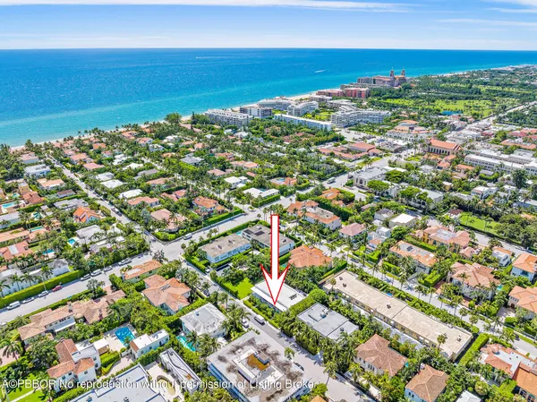 an aerial view of a city with lots of residential buildings ocean and mountain view in back