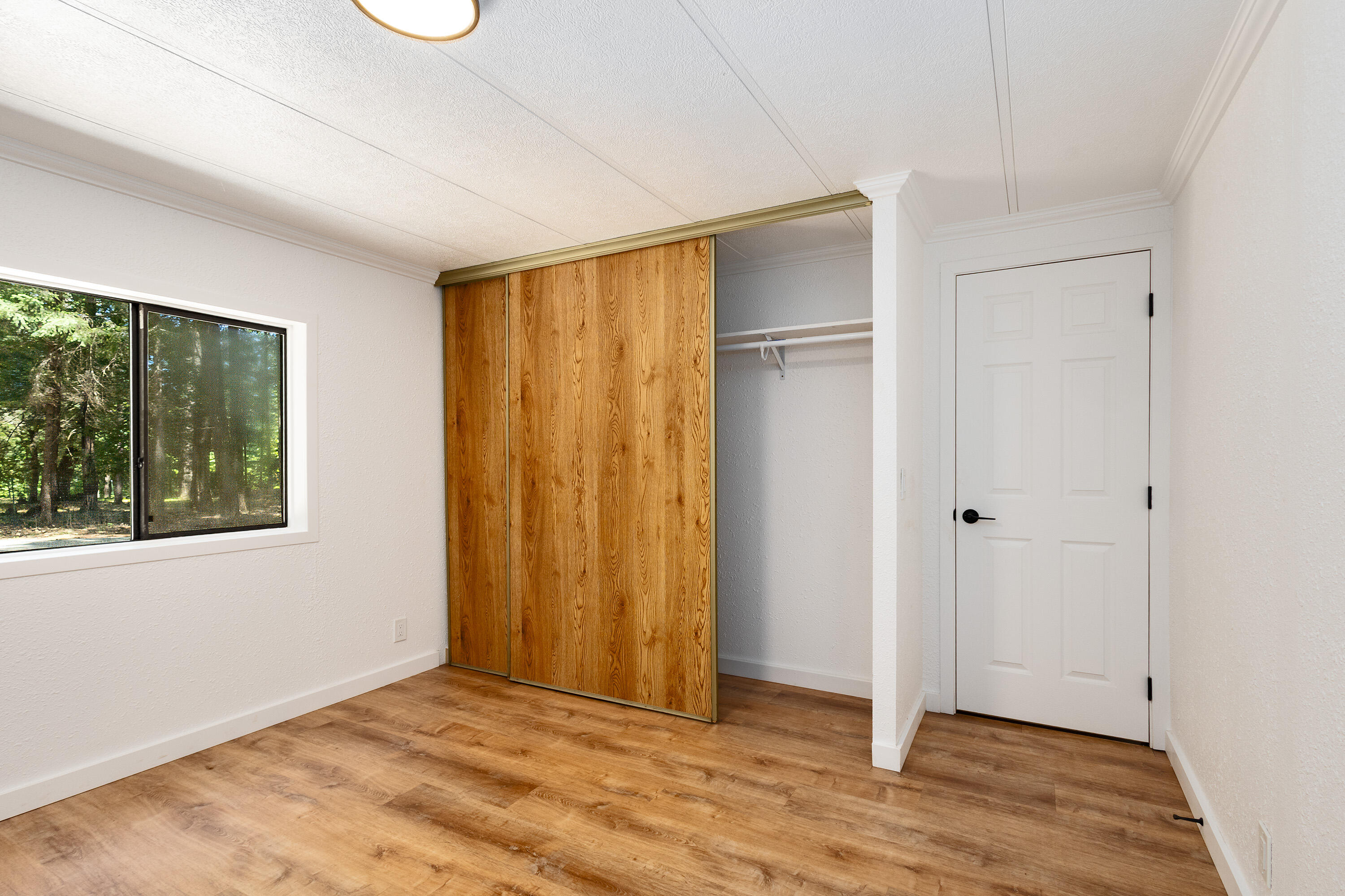 601 Pinewood Way Cave Junction, OR 97523 - Photo 16 of 33 a view of an empty room with wooden floor and a window