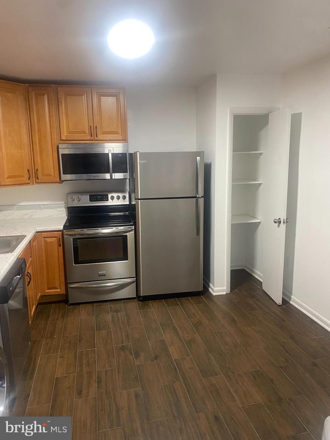 11393 Laurelwalk Drive, Unit B141 Laurel, MD 20708 - Photo 3 of 8 a kitchen with a refrigerator and a stove top oven