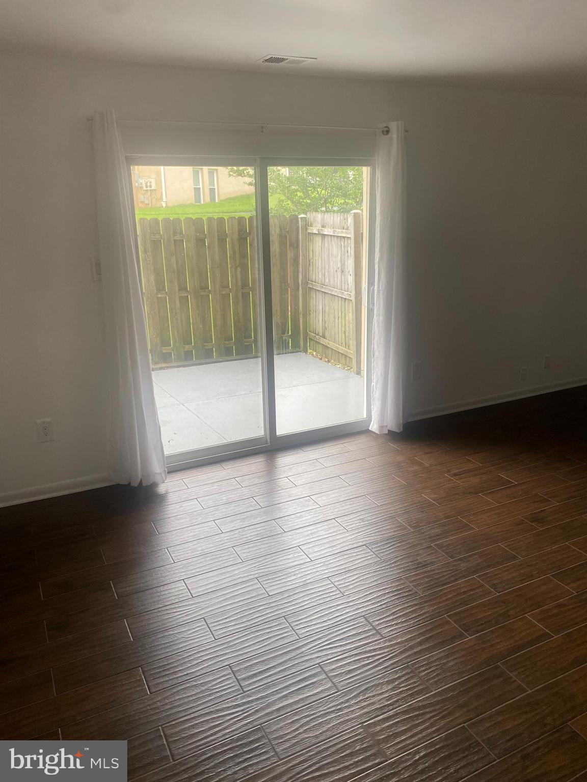 11393 Laurelwalk Drive, Unit B141 Laurel, MD 20708 - Photo 4 of 8 a view of an empty room with wooden floor and a window
