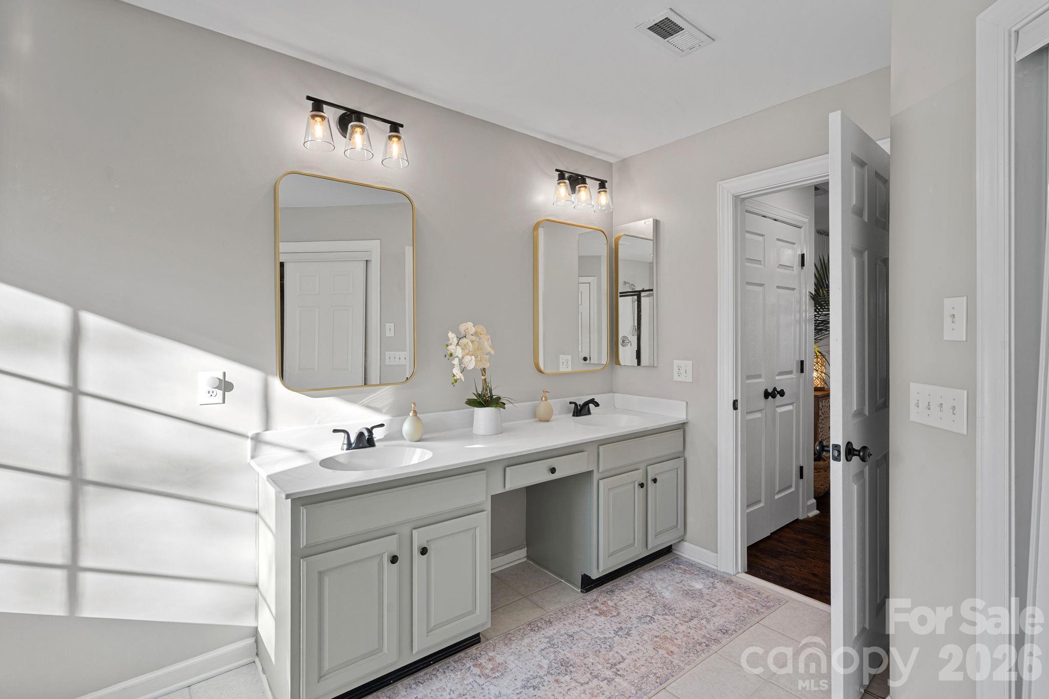 6110 Flowergate Lane Waxhaw, NC 28173 - Photo 23 of 39 a spacious bathroom with a double vanity sink a mirror and shower
