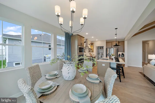 a dining room with furniture a kitchen and chandelier