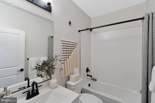 a bathroom with a bathtub shower sink and toilet