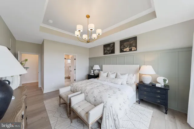 a spacious bedroom with a bed and a chandelier