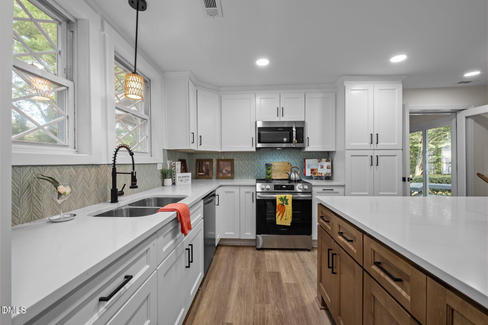 3014 Hope Valley Road Durham, NC 27707 - Photo 5 of 15 a kitchen with kitchen island granite countertop a sink appliances cabinets and a large window