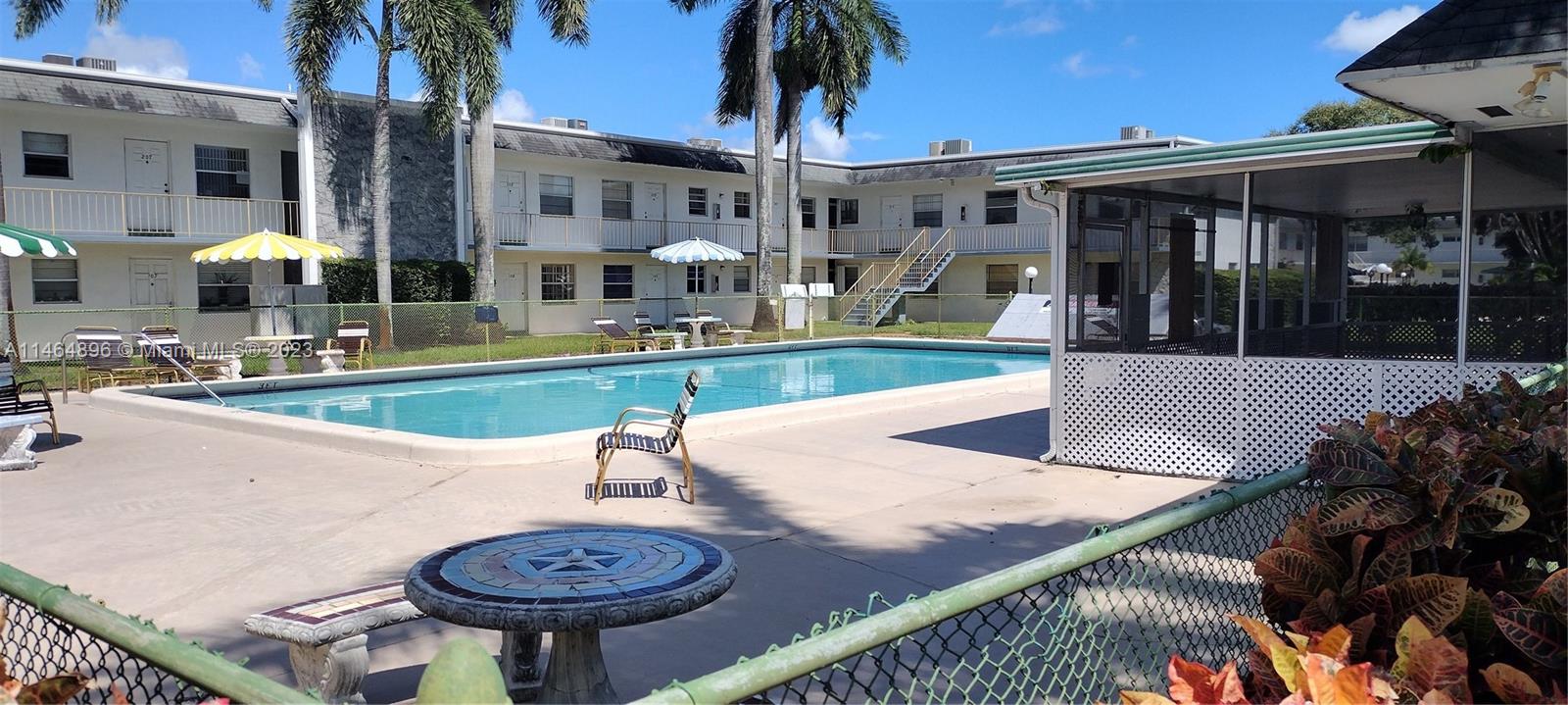 6201 Southwest 37th Street, Unit 209 Davie, FL 33314 - Photo 1 of 19 a view of a patio with table and chairs potted plants and palm tree