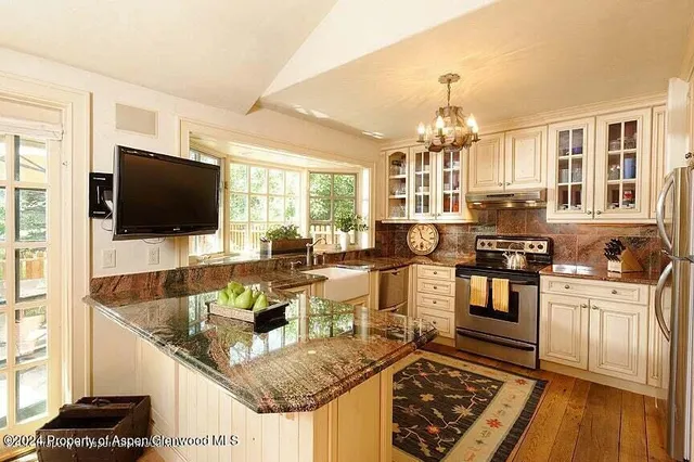 a living room with stainless steel appliances kitchen island granite countertop a stove and a sink