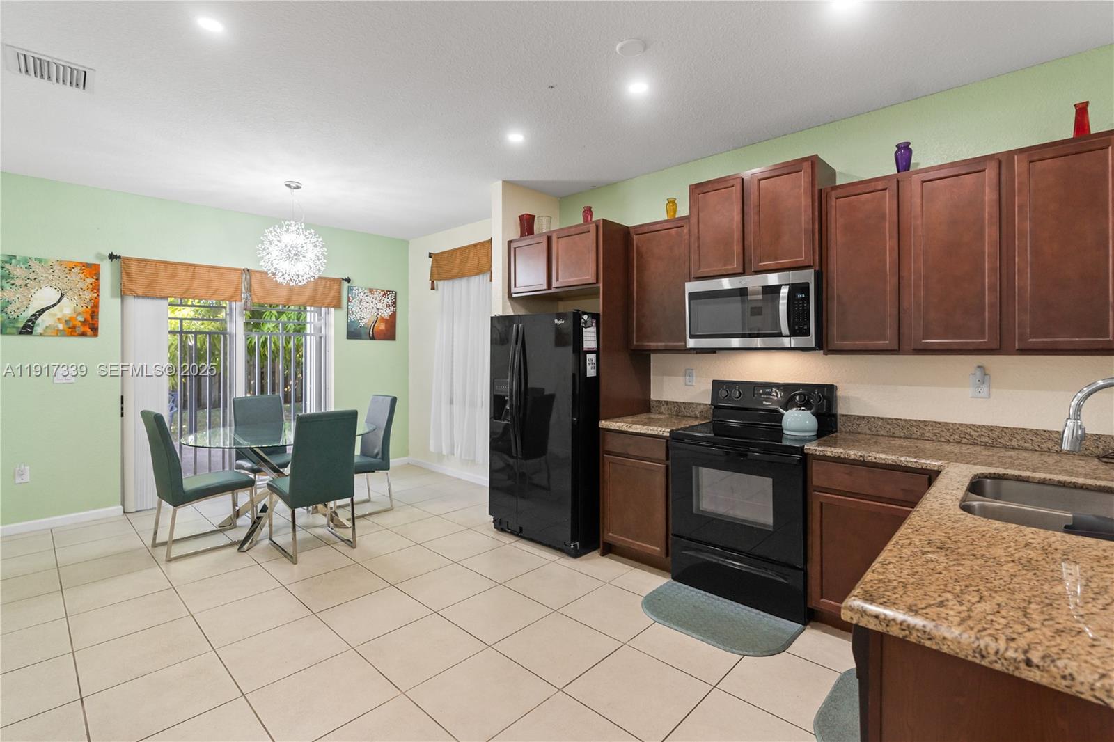 11121 Southwest 225th Terrace Miami, FL 33170 - Photo 19 of 41 a kitchen with stainless steel appliances granite countertop a refrigerator and a stove top oven