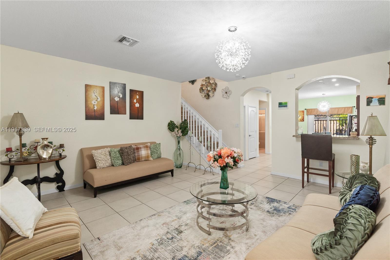 11121 Southwest 225th Terrace Miami, FL 33170 - Photo 25 of 41 a living room with furniture flowers and a chandelier