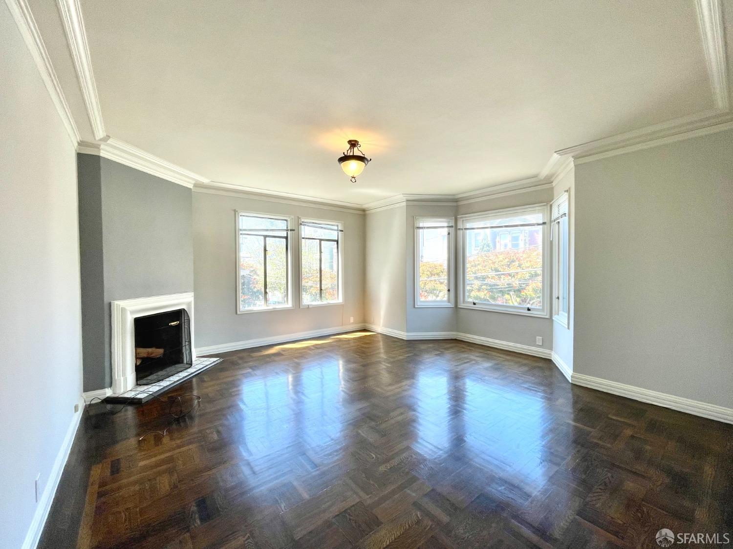 201 Waller Street San Francisco, CA 94102 - Photo 7 of 17 a view of an empty room with window and wooden floor