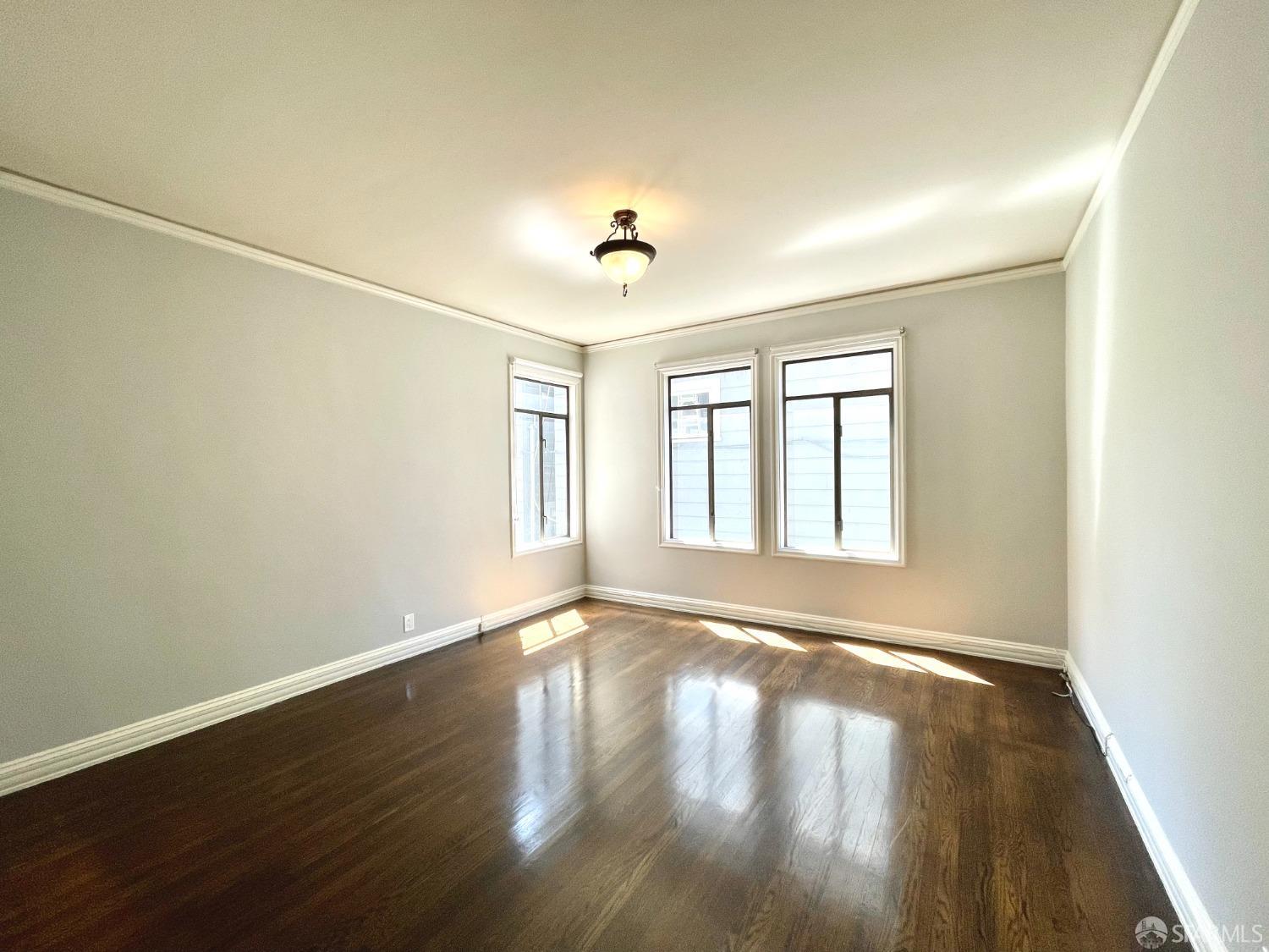 201 Waller Street San Francisco, CA 94102 - Photo 8 of 17 a view of an empty room with wooden floor and a window