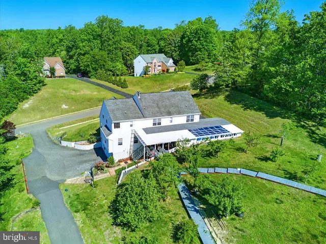 a large kitchen with kitchen island a large window cabinets a sink and stainless steel appliances