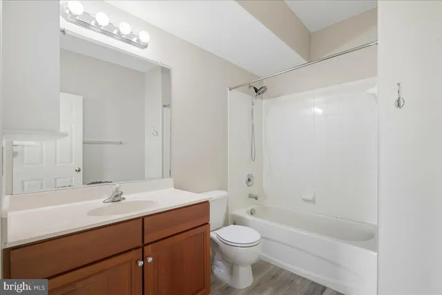 a bathroom with a granite countertop sink a toilet and shower