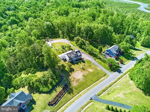 a view of a white house with a yard and potted plants