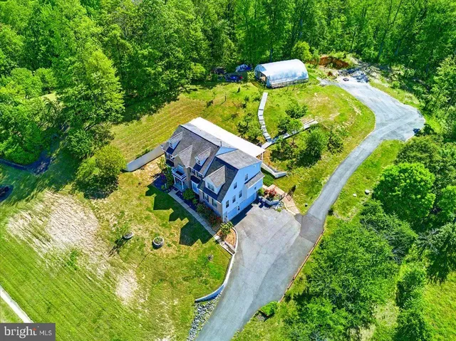 an aerial view of a house with a yard basket ball court and outdoor seating