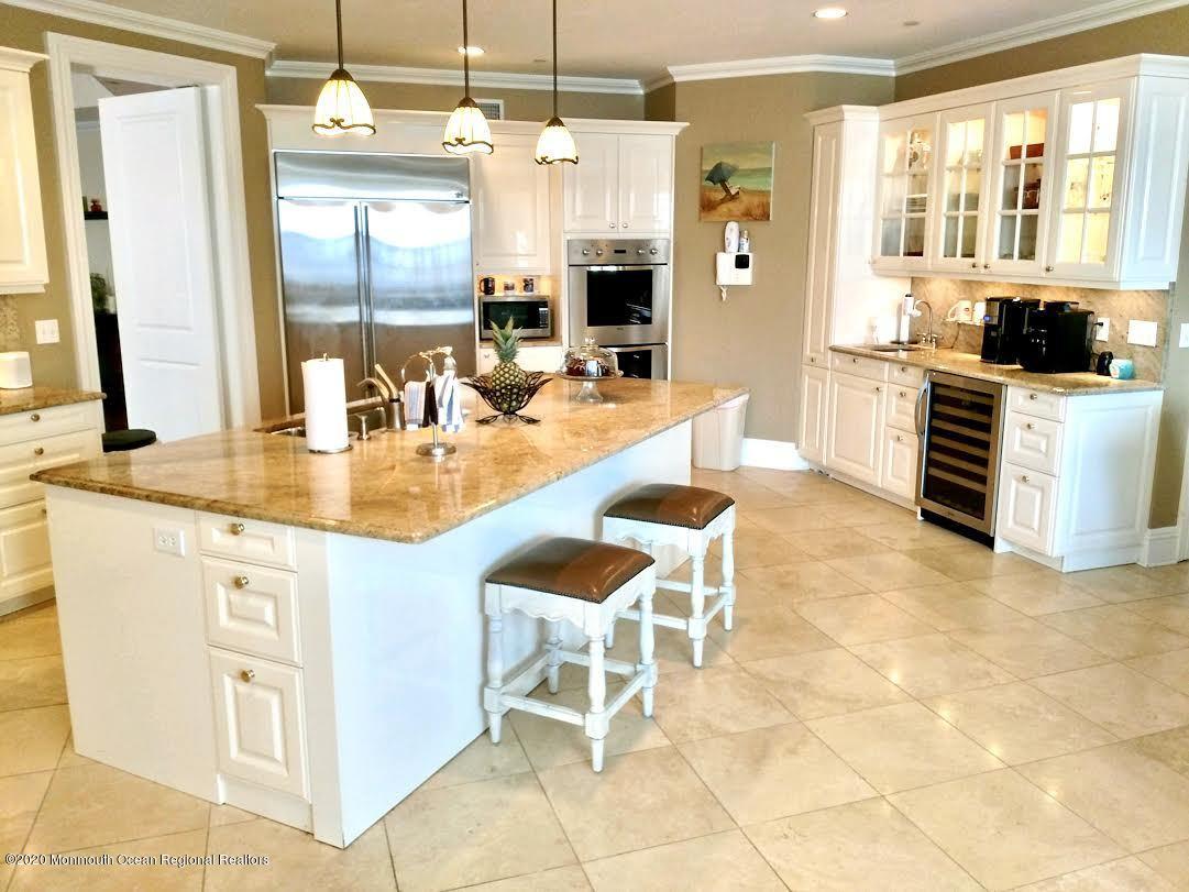 321 Oval Road Manasquan, NJ 08736 - Photo 7 of 23 a dining hall with stainless steel appliances kitchen island granite countertop a table and chairs in it