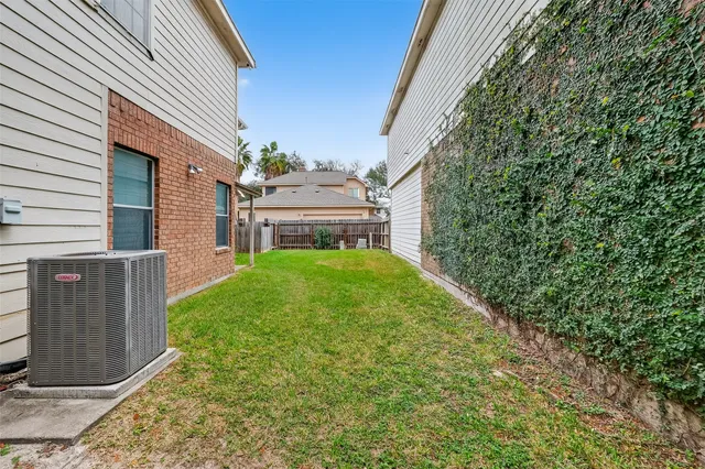 a view of a house with a small yard and wooden fence