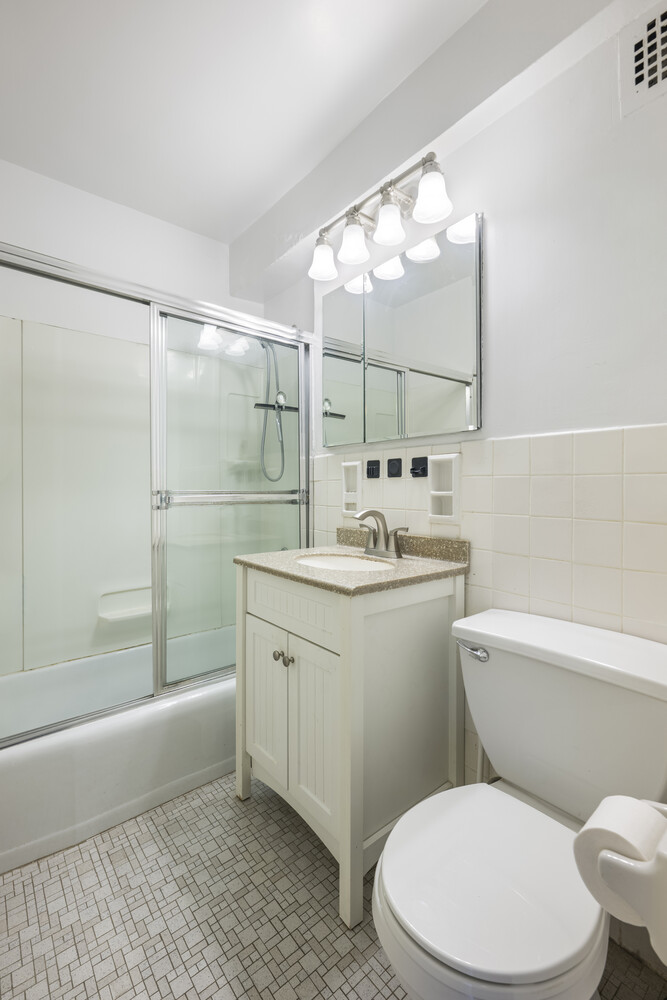 5700 Arlington Avenue, Unit 17N Bronx, NY 10471 - Photo 5 of 16 a bathroom with a sink a toilet a mirror and bathtub