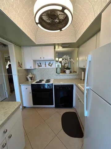 a kitchen with a sink a stove top oven and cabinetry