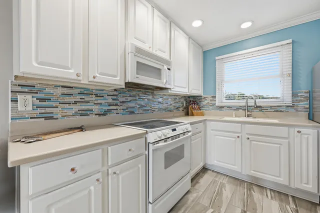 a kitchen with stainless steel appliances kitchen island a table and chairs in it