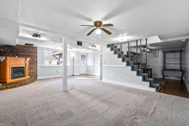a view of a livingroom with a fireplace and window