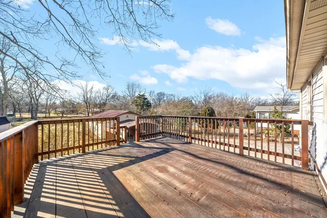 a view of balcony with wooden floor & fence