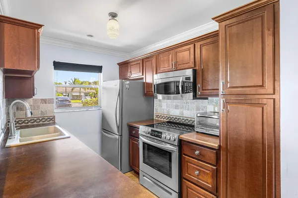 a kitchen with granite countertop a refrigerator stove and microwave