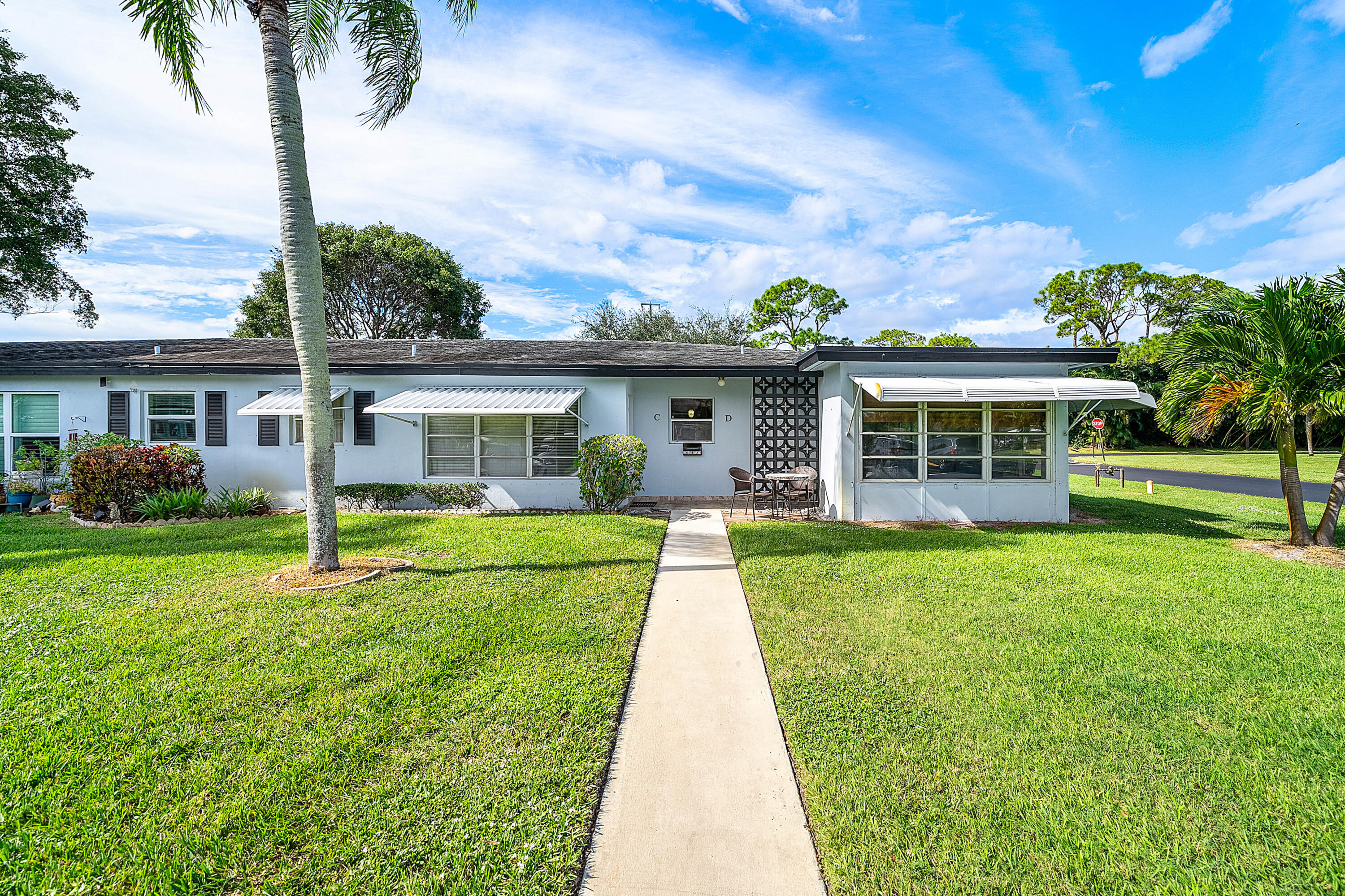 510 High Point Drive, Unit D Delray Beach, FL 33445 - Photo 2 of 23 front view of a house with a yard