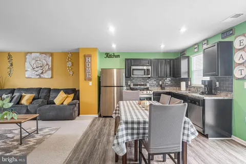 a kitchen with stainless steel appliances granite countertop a refrigerator a stove a sink dishwasher with a dining table and chairs