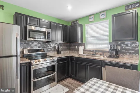 a kitchen with stainless steel appliances a stove sink microwave refrigerator and cabinets