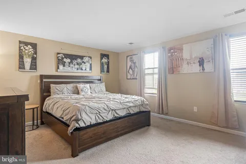 a spacious bedroom with a bed and wall painting